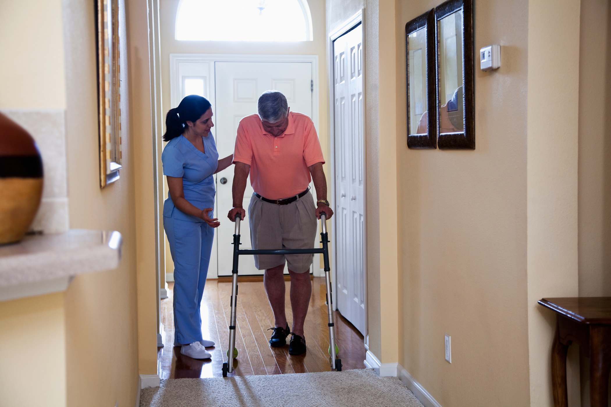 Home health aide with senior man using walker